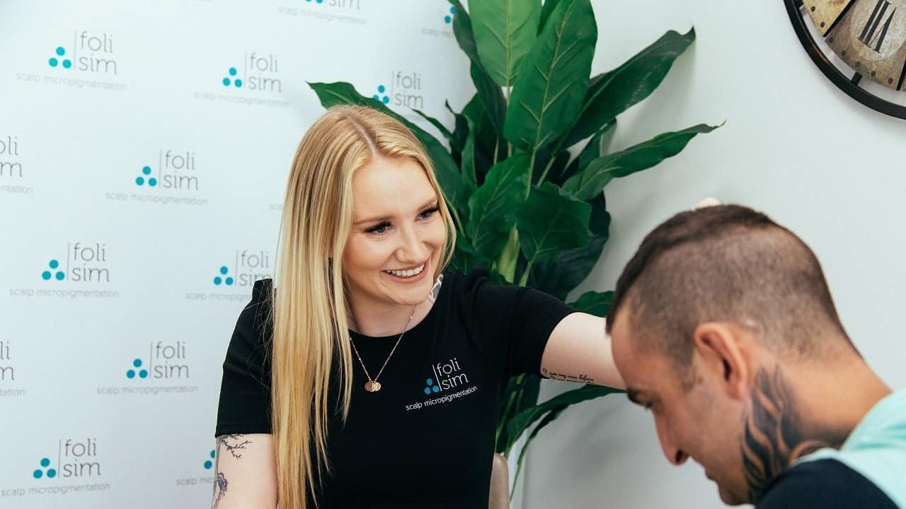 A Foli Sim artist talking a client through scalp micropigmentation